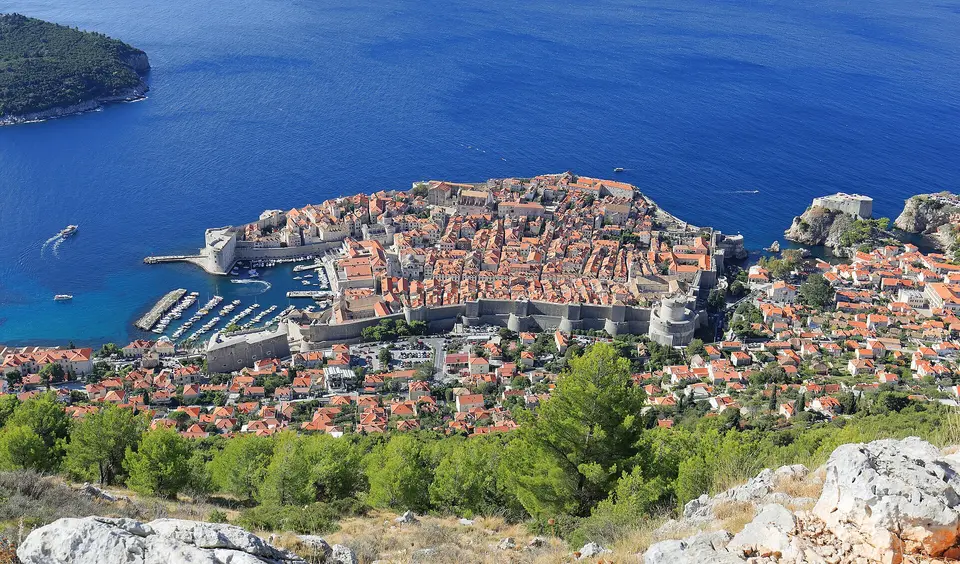 Pohled na hradby, červené střechy a přístav Dubrovníku.