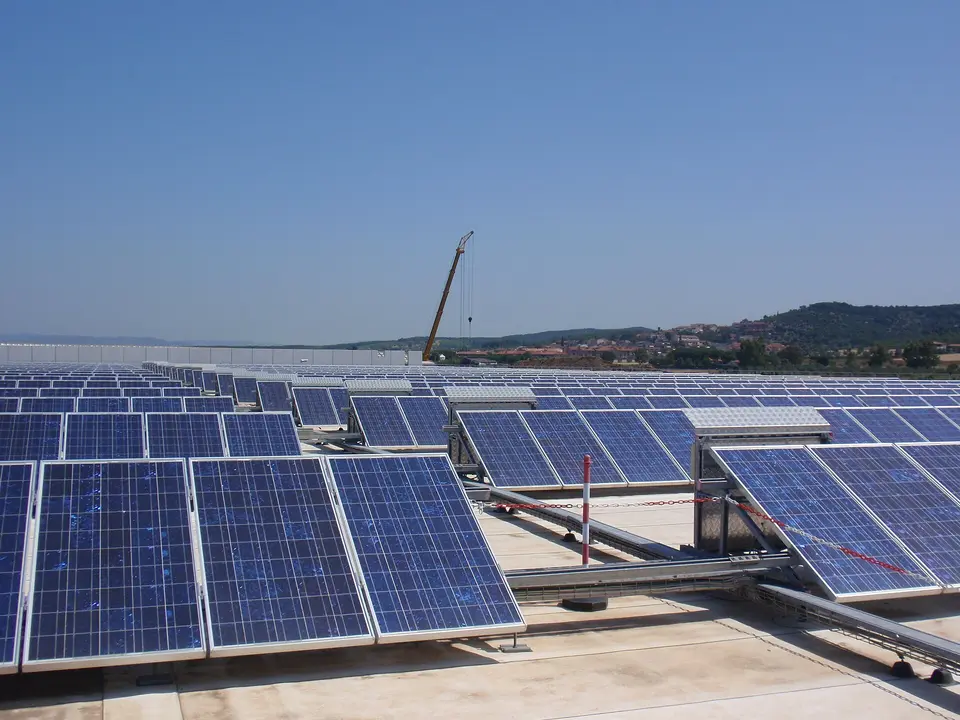 Řady fotovoltaických panelů na střeše.