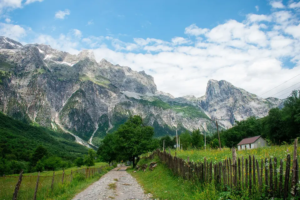 Strmé horské štíty nad zeleným údolím.