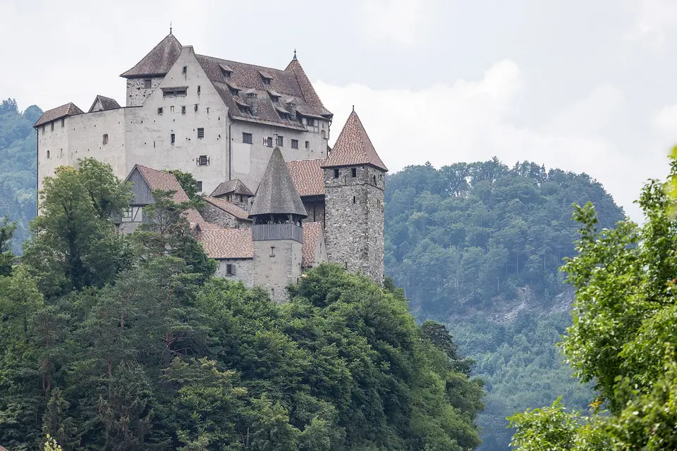 Hrad Gutenberg na kopci nad Balzersem, v pozadí alpské svahy.